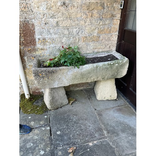 1020 - A weathered composition stone planter / trough of rectangular form raised on a pair of associated co... 