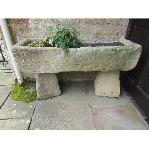 1020 - A weathered composition stone planter / trough of rectangular form raised on a pair of associated co... 