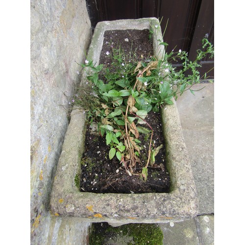 1020 - A weathered composition stone planter / trough of rectangular form raised on a pair of associated co... 