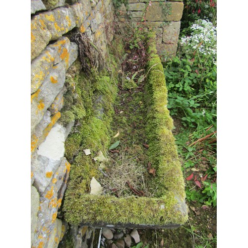 1023 - A long weathered natural stone planter / trough of rectangular form, raised on associated staddle su... 