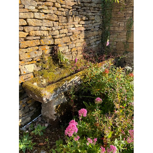 1023 - A long weathered natural stone planter / trough of rectangular form, raised on associated staddle su... 