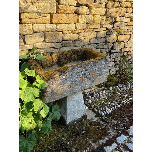 1028 - A weathered and lychen covered natural stone planter / trough of rectangular form raised on tall ass... 