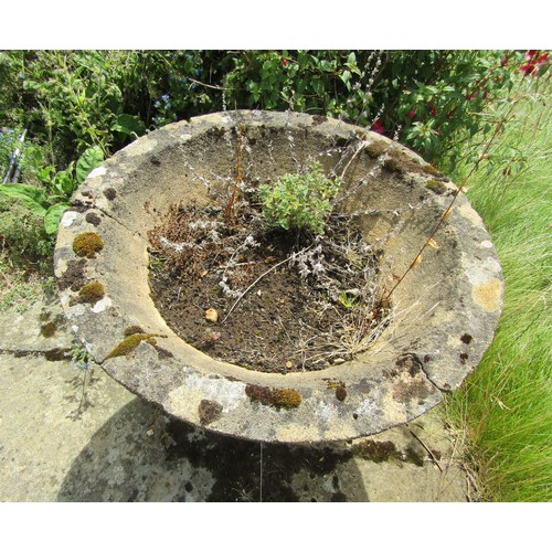 1034 - A weathered composition stone planter of tapering conical form raised on an associated plinth base, ... 