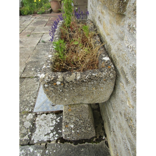 1043 - A weathered composition stone planter / trough of rectangular form raised on an associated pair of t... 