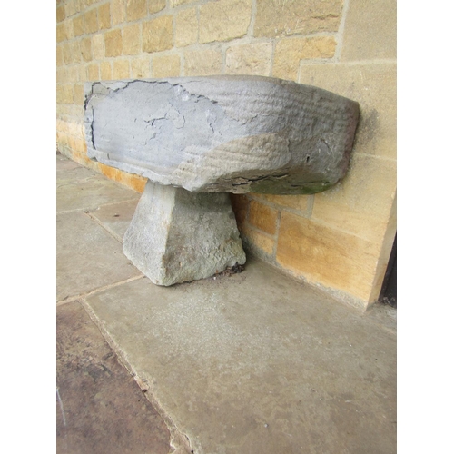 1051 - A roughly hewn weathered natural stone planter / trough of rectangular form raised on an associated ... 