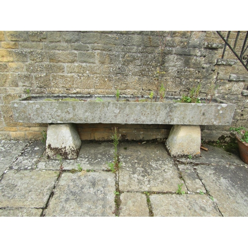 1053 - A long weathered natural stone planter / trough of rectangular form raised on an associated pair of ... 