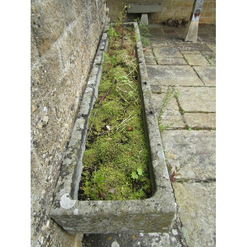 1053 - A long weathered natural stone planter / trough of rectangular form raised on an associated pair of ... 