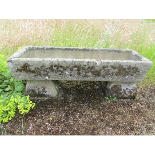 1058 - A weathered natural stone planter / trough of rectangular form raised on an associated pair of trest... 