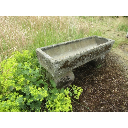 1058 - A weathered natural stone planter / trough of rectangular form raised on an associated pair of trest... 