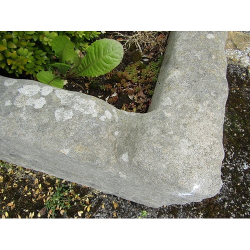 1063 - A large weathered natural stone planter / trough of rectangular form, planted with a well establishe... 