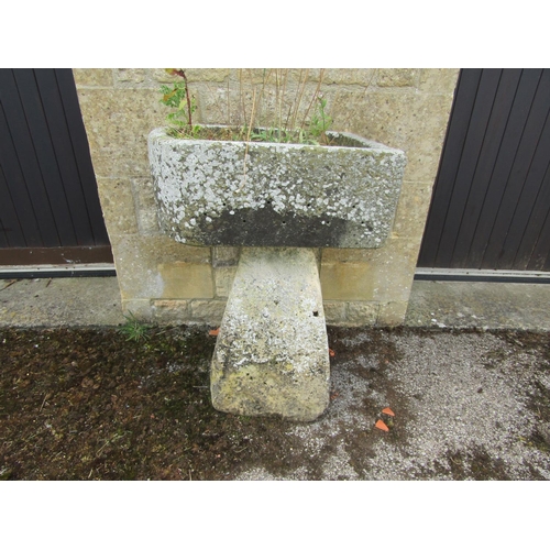 1065 - A small, neat weathered natural stone planter of rounded rectangular form, raised on an associated t... 