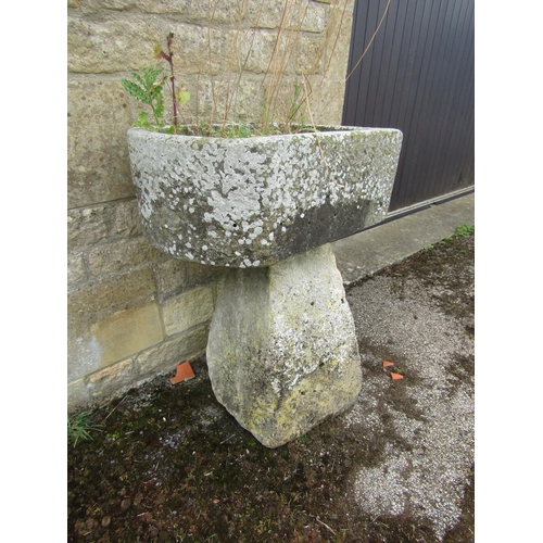 1065 - A small, neat weathered natural stone planter of rounded rectangular form, raised on an associated t... 