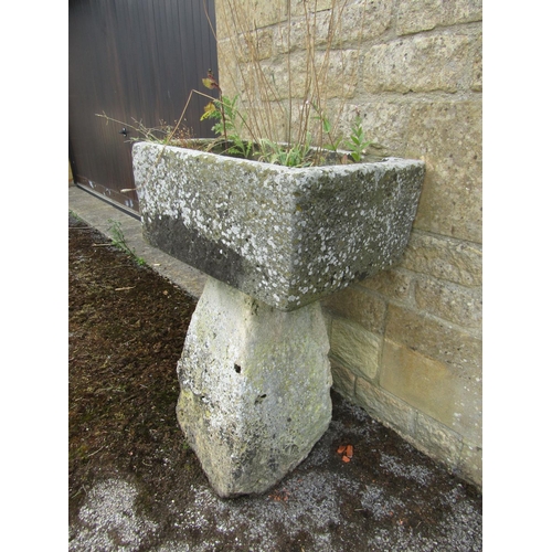 1065 - A small, neat weathered natural stone planter of rounded rectangular form, raised on an associated t... 