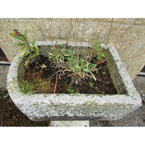 1065 - A small, neat weathered natural stone planter of rounded rectangular form, raised on an associated t... 