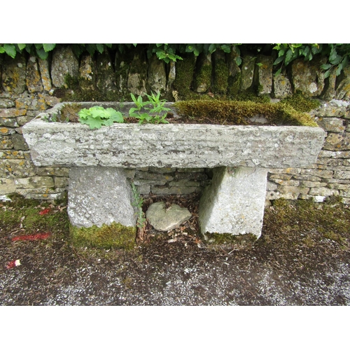 1071 - A weathered natural stone planter / trough of rectangular form, raised on a pair of associated stadd... 