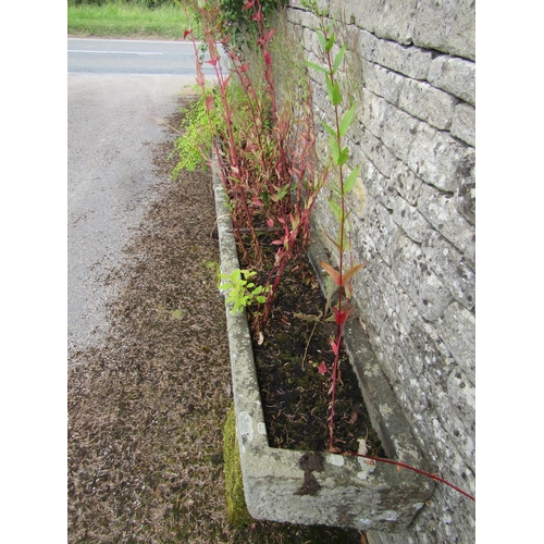 1073 - A very long weathered natural stone planter / trough of rectangular form, raised on a trio of associ... 