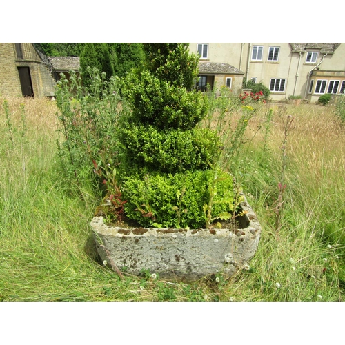 1076 - A large weathered natural stone planter of rounded squared form, with a well established box topiary... 