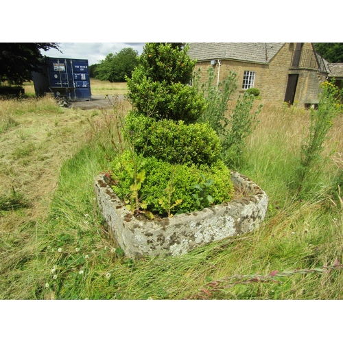 1076 - A large weathered natural stone planter of rounded squared form, with a well established box topiary... 