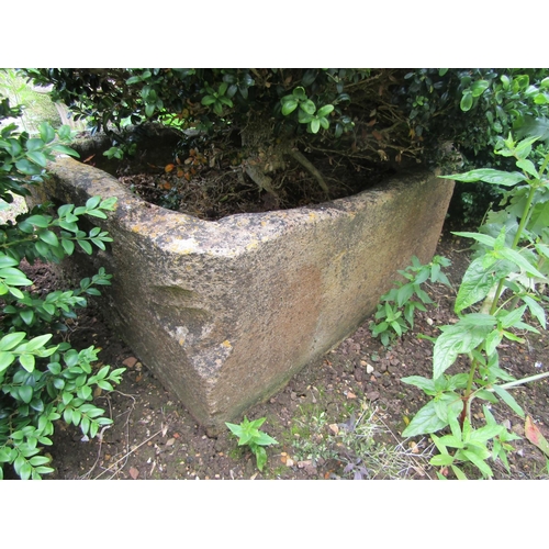 1079 - A large weathered natural stone planter of rounded squared form, with a well established box topiary... 