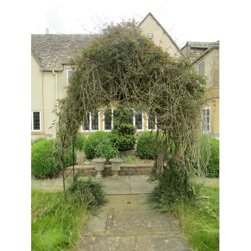 1080 - A cast iron scroll-work garden arbour, 260cm high, 206cm wide.