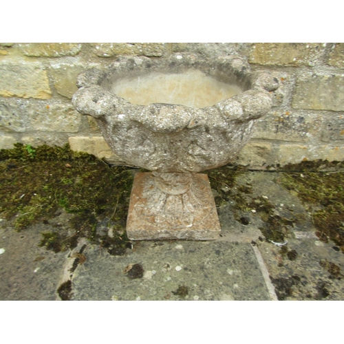 1085 - A composition stone garden planter of rounded foliate from raised on a squared plinth base, 45cm hig... 