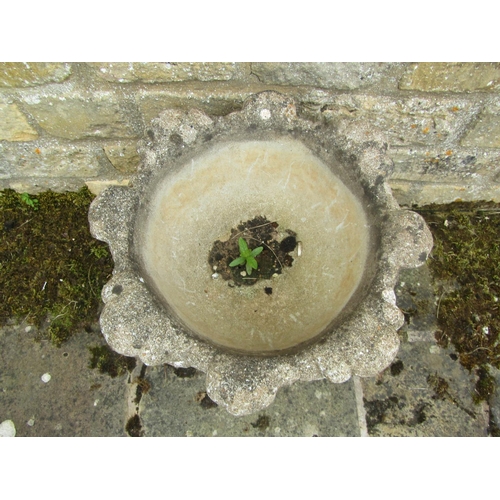 1085 - A composition stone garden planter of rounded foliate from raised on a squared plinth base, 45cm hig... 