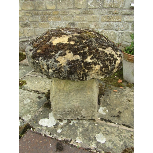 1086 - A weathered natural stone staddle stone and cap (with losses to cap) 63cm high, 60cm diameter approx... 