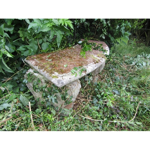 1094 - A weathered composition stone bench with curved seat and moulded supports, 38cm high, 133cm wide. 

... 