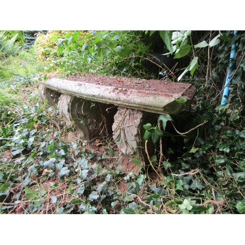 1094 - A weathered composition stone bench with curved seat and moulded supports, 38cm high, 133cm wide. 

... 