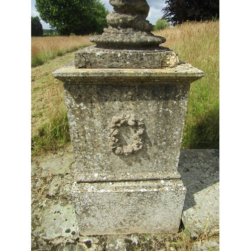 1097 - A monumental pair of 19th century weathered composition stone garden urns, raised on associated plin... 