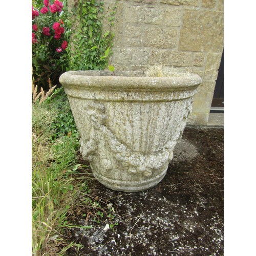 1064 - A pair of weathered cast composition stone planters of tapering cylindrical form with moulded garlan... 