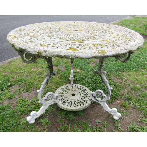 1254 - A painted and weathered heavy gauge cast alloy garden terrace table, the decorative pierced circular... 