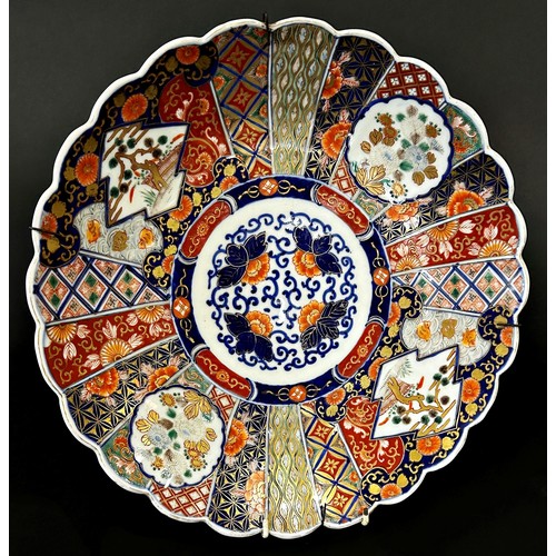 81 - A 19th century Japanese Imari charger with floral and geometric detail within a fluted edge, 37cm di... 