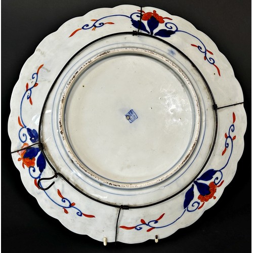 81 - A 19th century Japanese Imari charger with floral and geometric detail within a fluted edge, 37cm di... 