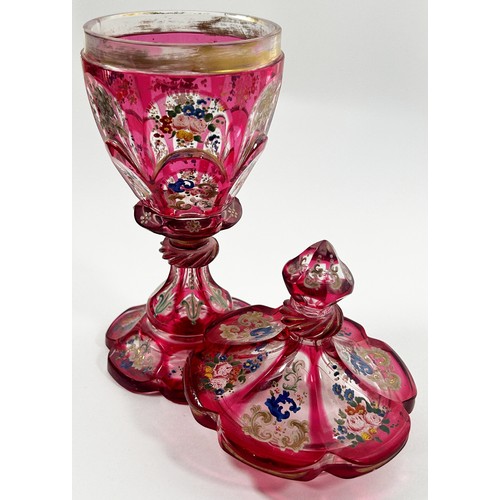 185 - A Bohemian faceted pink glass goblet with hand painted floral decoration, together with a cover, 22c... 