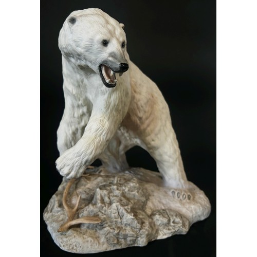 96 - A Franklin Mint hand painted porcelain figure of a polar bear on a rocky out crop, 26cm high