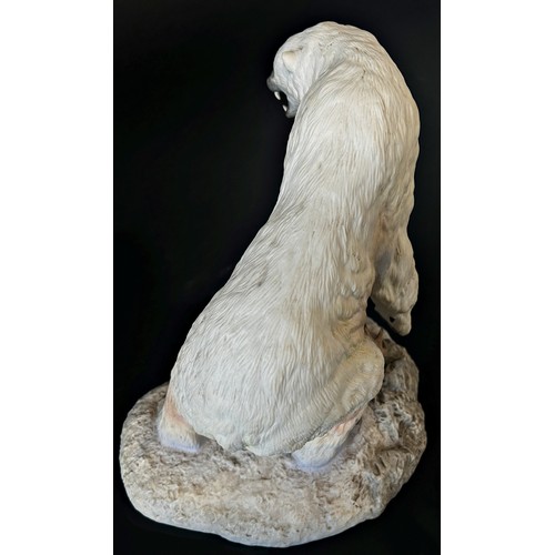 96 - A Franklin Mint hand painted porcelain figure of a polar bear on a rocky out crop, 26cm high