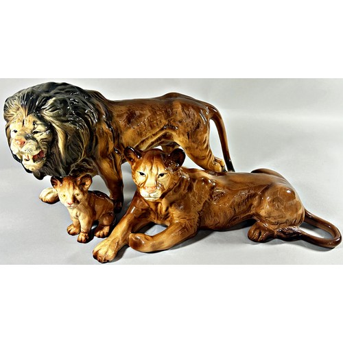 57 - A Melba ware group of three lions; male, female and cub, 40cm long and smaller (3)