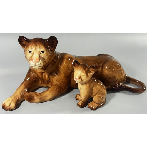 57 - A Melba ware group of three lions; male, female and cub, 40cm long and smaller (3)