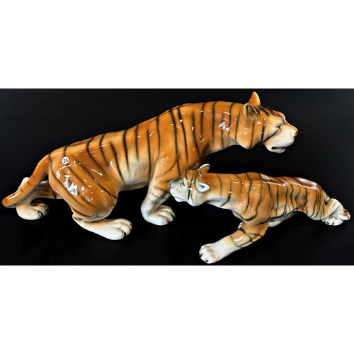 58 - A group of four Royal Dux figures comprising two tigers and two leopards, 415cm long and smaller (4)