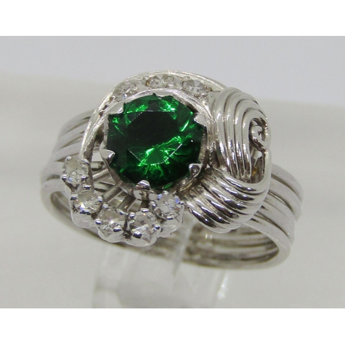 312 - Stylised white metal dress ring set with green paste and diamonds, size M, 7.7g