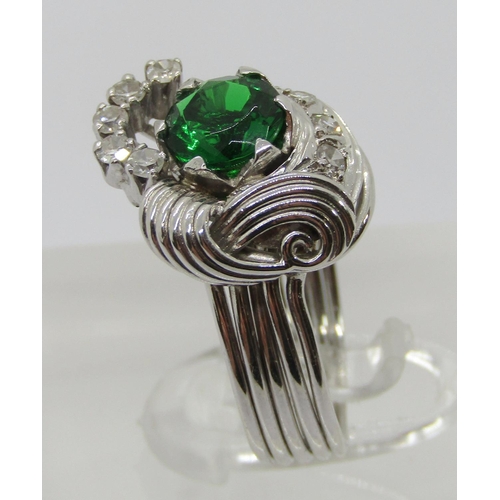 312 - Stylised white metal dress ring set with green paste and diamonds, size M, 7.7g