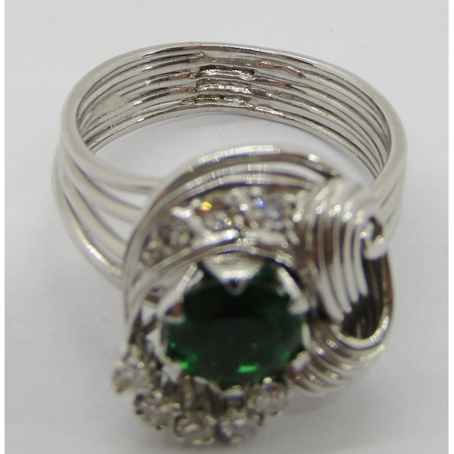 312 - Stylised white metal dress ring set with green paste and diamonds, size M, 7.7g