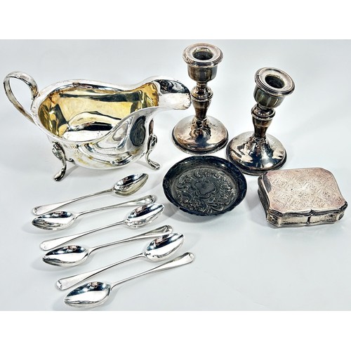 244 - A silver collection to include a late Victorian scrolled pin tray, a pair of candlesticks, a gravy b... 