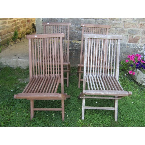 1024 - A set of four contemporary stained and weathered teak folding garden chairs with slender slatted sea... 