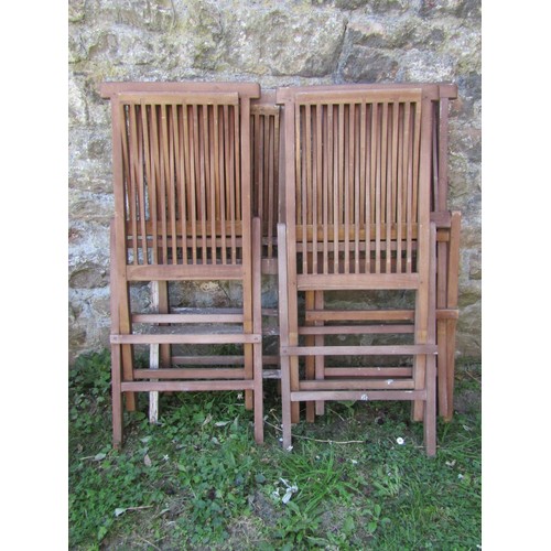 1024 - A set of four contemporary stained and weathered teak folding garden chairs with slender slatted sea... 