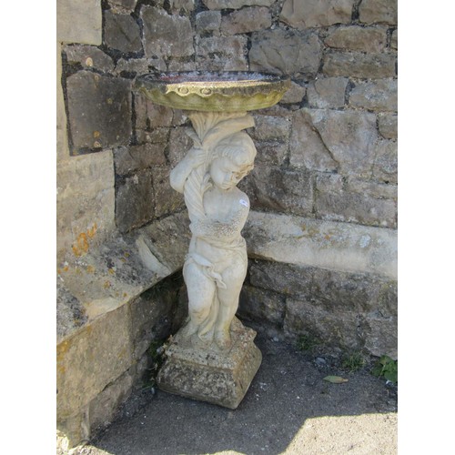 1015 - A two sectional weathered cast composition stone bird bath, the pedestal in the form of a standing c... 