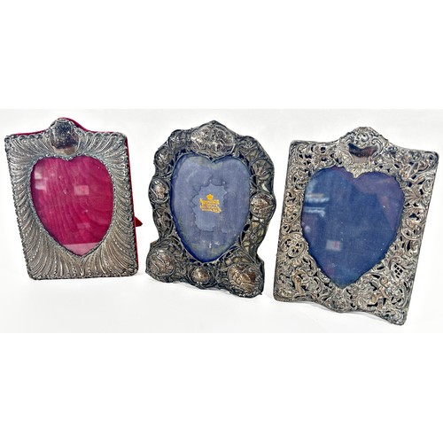 250 - Three silver heart shaped photograph frames; two decorated with cherubs and cupids, a Mappin & Webb ... 