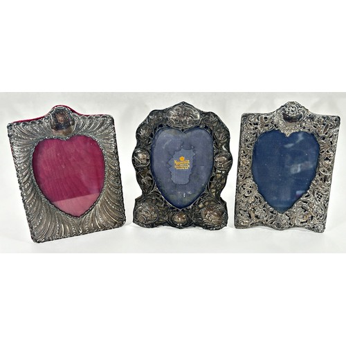 250 - Three silver heart shaped photograph frames; two decorated with cherubs and cupids, a Mappin & Webb ... 