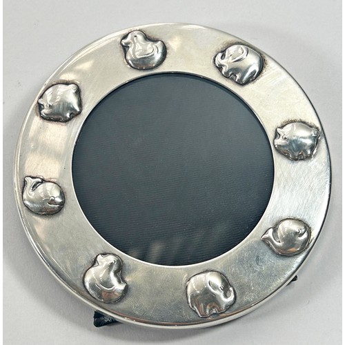 253 - A Tiffany silver circular babies photo frame decorated with duckling and piglets, etc, 6 cm diameter... 